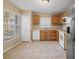 Well-lit kitchen featuring stainless steel refrigerator, tile floors, and wood cabinets at 3441 Grenville Dr, Winter Haven, FL 33884