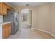 View of the kitchen with stainless steel refrigerator, adjacent dining area, and tile floors at 3441 Grenville Dr, Winter Haven, FL 33884