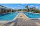 Large community pool with multiple sections, surrounded by palm trees and lounge chairs at 3441 Grenville Dr, Winter Haven, FL 33884
