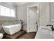 Elegant bathroom with freestanding bathtub, wood-like tile, and modern fixtures at 3960 Laurel Se Ave, Lakeland, FL 33812