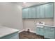 Bright laundry room with light blue shaker cabinets and a farmhouse sink at 3960 Laurel Se Ave, Lakeland, FL 33812
