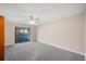 Spacious bedroom with grey carpet, ceiling fan, and sliding glass door to patio at 410 N Tecumseh Ave, Fort Meade, FL 33841