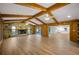 Open living room with wood beams, stone fireplace, and view to kitchen at 410 N Tecumseh Ave, Fort Meade, FL 33841