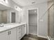 Bathroom with double vanity, white cabinets, and a glass-enclosed shower, blending style and functionality at 447 Ituna Cir, Winter Haven, FL 33881