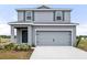 Charming two-story home with gray siding and a two-car garage, showcasing modern curb appeal at 447 Ituna Cir, Winter Haven, FL 33881