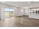 Spacious living area with wood-look flooring, large sliding doors, and a view of the kitchen at 447 Ituna Cir, Winter Haven, FL 33881