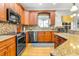 Modern kitchen with granite countertops, stainless steel appliances, and wood cabinets at 5171 Deeson Pointe Ct, Lakeland, FL 33805