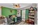 Cozy bedroom with green walls, bookcase, and ceiling fan at 5576 Albert Williams Rd, Mulberry, FL 33860