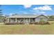 House exterior features a gray metal roof, light gray siding, and a stone accented front porch at 5576 Albert Williams Rd, Mulberry, FL 33860