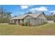 Gray house with metal roof, stone accents, and landscaping. Located on a spacious lot at 5576 Albert Williams Rd, Mulberry, FL 33860