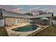 Kidney shaped pool with patio furniture and umbrella at 5576 Albert Williams Rd, Mulberry, FL 33860