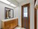 Clean bathroom with wood vanity, mirror, and exterior access at 6004 Greenleaf Cir, Winter Haven, FL 33884