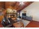Living room with a stone fireplace, wood beams, and comfortable seating at 6004 Greenleaf Cir, Winter Haven, FL 33884