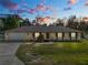 Single-story house with attached garage and brick accents, at dusk at 7101 Scenic Pl, Lakeland, FL 33810
