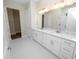 Double vanity bathroom with marble countertop and hexagon tile floor at 715 Teaberry Trl, Polk City, FL 33868