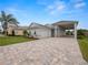 Single-story home with light-colored siding, paver driveway, and landscaping at 715 Teaberry Trl, Polk City, FL 33868
