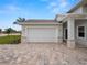 White garage door with paver driveway and stone accents at 715 Teaberry Trl, Polk City, FL 33868