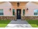 Modern front door with stone accents and welcome sign at 748 Mcclellan Rd, Frostproof, FL 33843