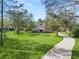 Two-story house with a curved driveway and green lawn, surrounded by trees at 748 Mcclellan Rd, Frostproof, FL 33843