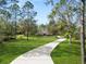 Two-story house with a curved driveway surrounded by tall trees and lush lawn at 748 Mcclellan Rd, Frostproof, FL 33843