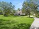 Two-story house with a curved driveway, showcasing a manicured lawn and trees at 748 Mcclellan Rd, Frostproof, FL 33843
