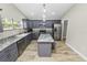 Modern kitchen with gray cabinets, granite counters, and island at 748 Mcclellan Rd, Frostproof, FL 33843