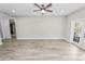 Bright living room with wood-look floors, ceiling fan, and access to backyard at 748 Mcclellan Rd, Frostproof, FL 33843