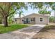 Charming house with teal door and large oak tree at 107 W 7Th St, Frostproof, FL 33843