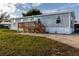 Single-wide mobile home with wood deck and steps at 1126 Lakewood W Cir, Lakeland, FL 33801