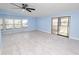 Spacious living room with light blue walls, ceiling fan, and wood-look flooring, and sliding glass doors at 2206 Golden Horseshoe N Cir, Lakeland, FL 33810