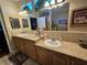 Bathroom featuring granite counters, double sinks with wooden cabinets, and a large framed mirror with lights at 2356 Peavine Cir # 1017, Lakeland, FL 33810