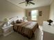 Comfortable bedroom featuring a queen-size bed, ceiling fan and views of the lake beyond the window at 2356 Peavine Cir # 1017, Lakeland, FL 33810