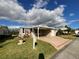 Exterior of a single-story home with a covered carport, manicured lawn, and lovely landscaping at 2356 Peavine Cir # 1017, Lakeland, FL 33810