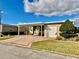Exterior of a single-story home featuring a covered carport, garage, and well-maintained landscaping at 2356 Peavine Cir # 1017, Lakeland, FL 33810