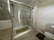 A glass enclosed walk-in shower features tile surround, a shower head, and a safety bar at 2356 Peavine Cir # 1017, Lakeland, FL 33810