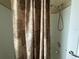 Close-up of a shower featuring a textured curtain, adjustable shower head, and chrome fixtures at 2356 Peavine Cir # 1017, Lakeland, FL 33810