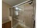 Walk-in shower features sliding glass door, chrome fixtures, tiled surround, and grab bar at 2356 Peavine Cir # 1017, Lakeland, FL 33810