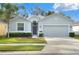 Single-story house with gray siding, two-car garage, and landscaped lawn at 3710 Madbury Cir, Lakeland, FL 33810