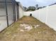 Narrow strip of backyard to the side of the house with vinyl fencing at 4018 Sundance Place Loop, Mulberry, FL 33860