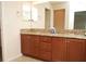Bathroom with a granite topped double vanity and wood cabinets at 4018 Sundance Place Loop, Mulberry, FL 33860