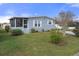Quaint manufactured home with a well-manicured lawn and shrubs at 5079 Lodgewood Dr, Lakeland, FL 33810