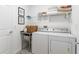Functional laundry room with washer, dryer, and storage shelves at 636 Trotters Dr, Eagle Lake, FL 33839