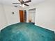 Well-lit bedroom with teal carpet, ceiling fan, and ample closet space at 6929 Farris Dr, Lakeland, FL 33811