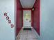 Front entry with a light gray door and red-accented walls at 6929 Farris Dr, Lakeland, FL 33811