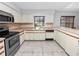 View of the kitchen with white cabinets, stainless steel appliances, and tile floor at 6929 Farris Dr, Lakeland, FL 33811