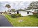 White single story home with green lawn and palm trees at 726 Erie Ct, Lakeland, FL 33803