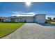 Beautiful light blue home with a large three-car garage and well-manicured lawn at 1010 Crossroads Dr, Polk City, FL 33868