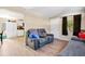 View of living room and kitchen with gray reclining sofas and wood-look floors at 1133 N Brunnell Pkwy, Lakeland, FL 33805
