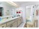 Bathroom featuring double sinks, a large mirror, and neutral-toned cabinets and flooring at 1452 Grand Cayman Cir, Winter Haven, FL 33884