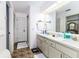 Bathroom featuring double sinks, a large mirror, neutral-toned cabinets, and a shower at 1452 Grand Cayman Cir, Winter Haven, FL 33884